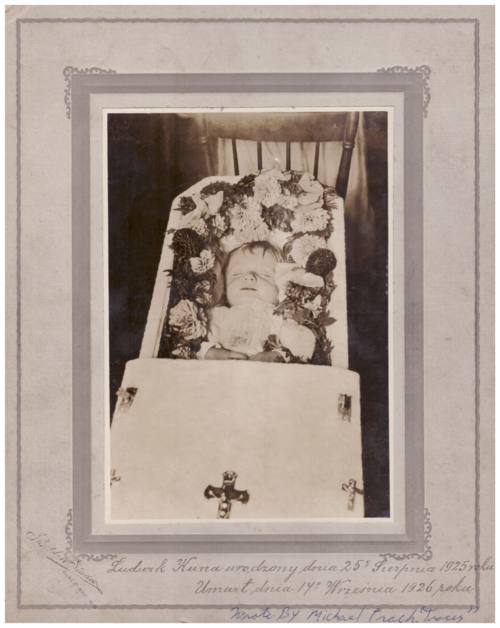 Photograph of child in coffin. Caption reads: 'Ludwik Kuna, born August 25, 1925, died September, 1926.' Signed: 'Wrote by Michael Trach "Tracz"'.